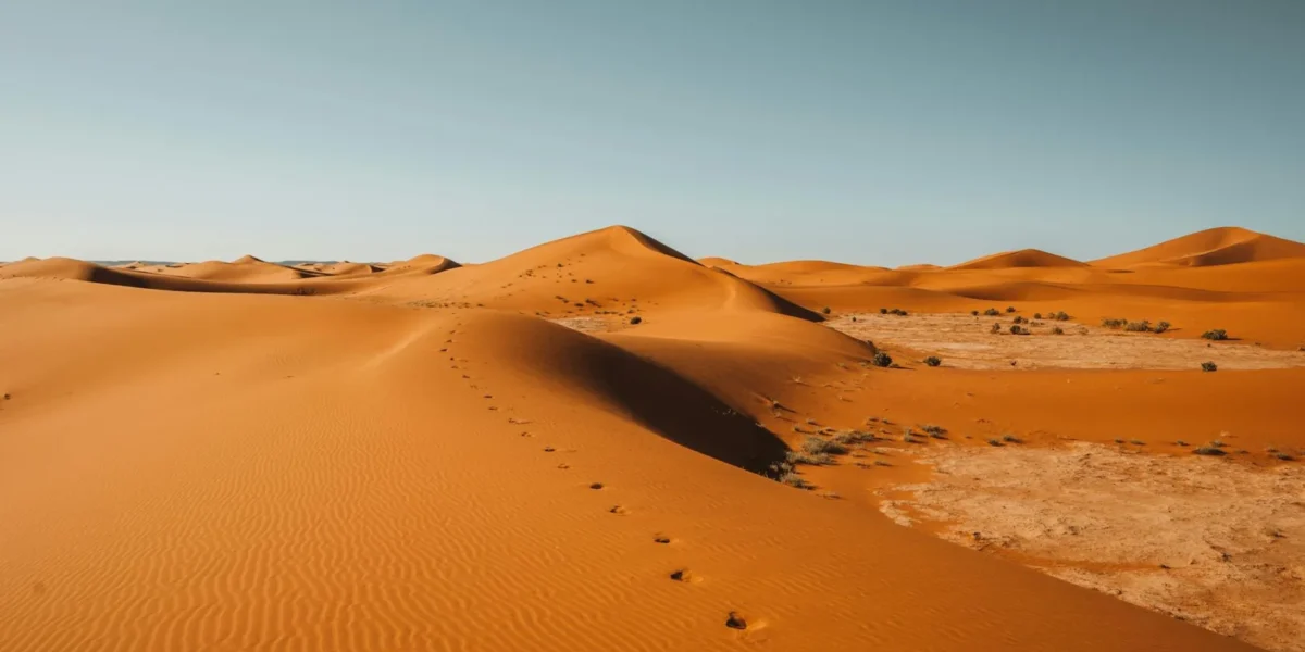 A breathtaking view of the Sahara Desert's sand dunes with clear sky in Morocco.