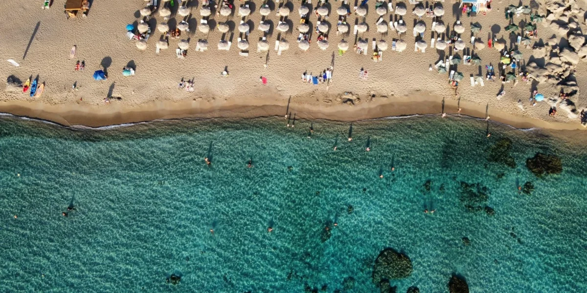 Aerial view of Chania beach, Greece with umbrellas and turquoise water.
