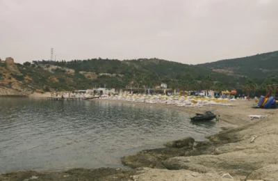 A serene beach with chairs and rocky coastline in Izmir, Turkey.