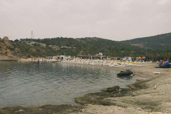 A serene beach with chairs and rocky coastline in Izmir, Turkey.