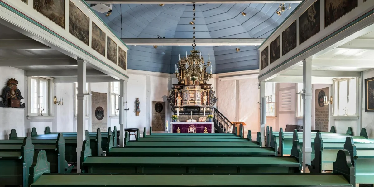 Interior view of a historic church in Geesthacht, featuring traditional wooden pews and altar.