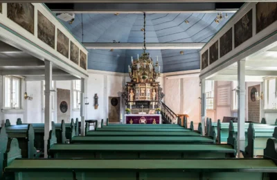 Interior view of a historic church in Geesthacht, featuring traditional wooden pews and altar.