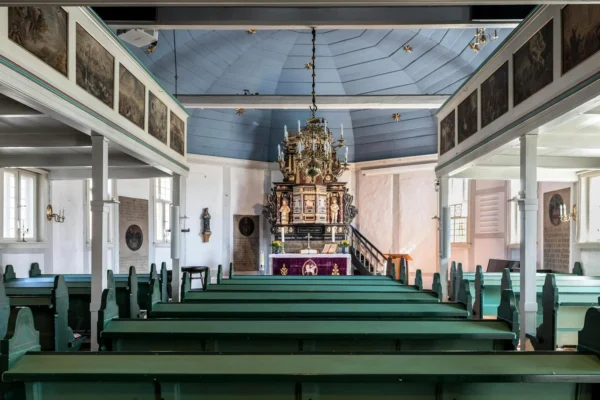 Interior view of a historic church in Geesthacht, featuring traditional wooden pews and altar.