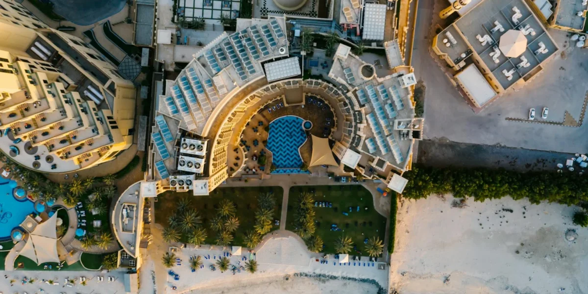 Stunning aerial view of a luxury resort hotel on a beach, showcasing intricate architecture and a scenic coastline.