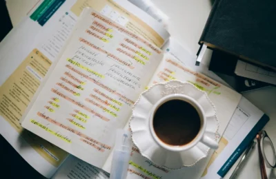 A cup of coffee on handwritten Spanish notes for language learning inspiration.