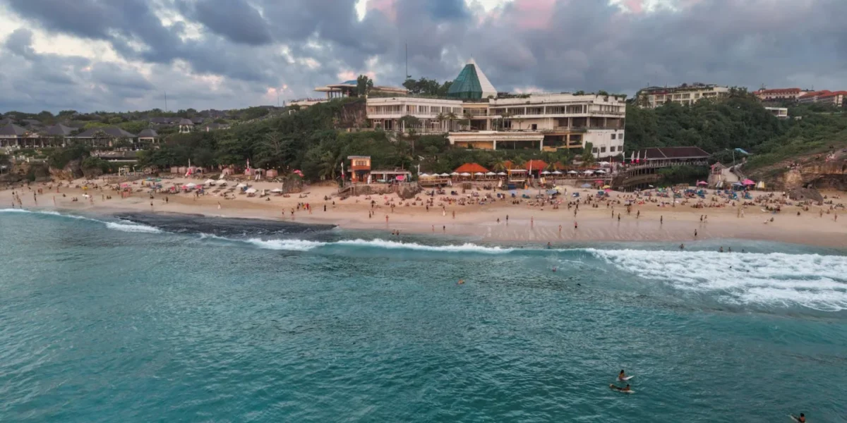 Scenic aerial view of a beachfront resort in Bali, Indonesia at sunset.