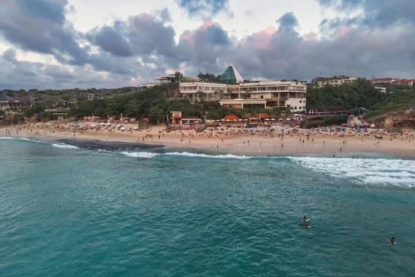 Scenic aerial view of a beachfront resort in Bali, Indonesia at sunset.