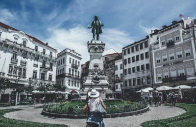 Monumental statue in a bustling Porto square, capturing local life and architecture.