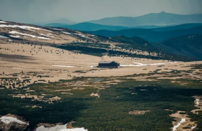 A scenic view of a secluded lodge in the Czech countryside surrounded by mountainous landscapes.