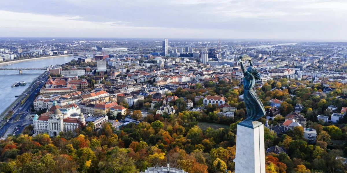 Stunning aerial view of Budapest with the iconic Liberty Statue overlooking the city and Danube River.