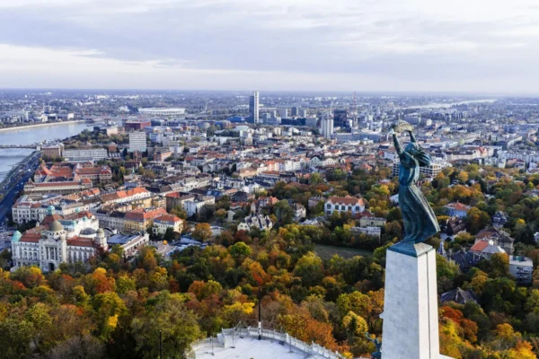 Stunning aerial view of Budapest with the iconic Liberty Statue overlooking the city and Danube River.