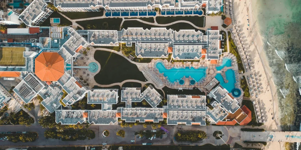 Stunning aerial view of a luxury resort in Playa del Carmen, featuring pools and beach access.