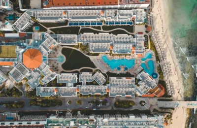 Stunning aerial view of a luxury resort in Playa del Carmen, featuring pools and beach access.