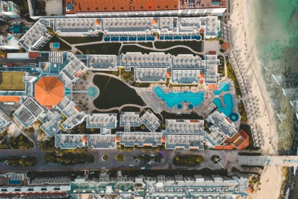 Stunning aerial view of a luxury resort in Playa del Carmen, featuring pools and beach access.
