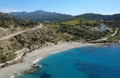 Stunning aerial view of Triopetra Beach showcasing the vibrant blue sea and surrounding hills in Crete, Greece.