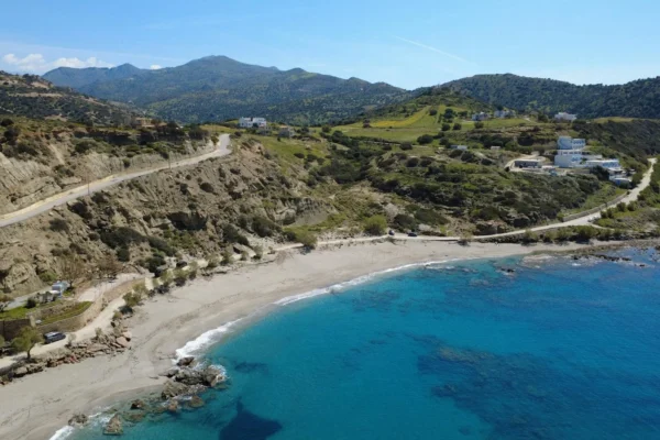 Stunning aerial view of Triopetra Beach showcasing the vibrant blue sea and surrounding hills in Crete, Greece.