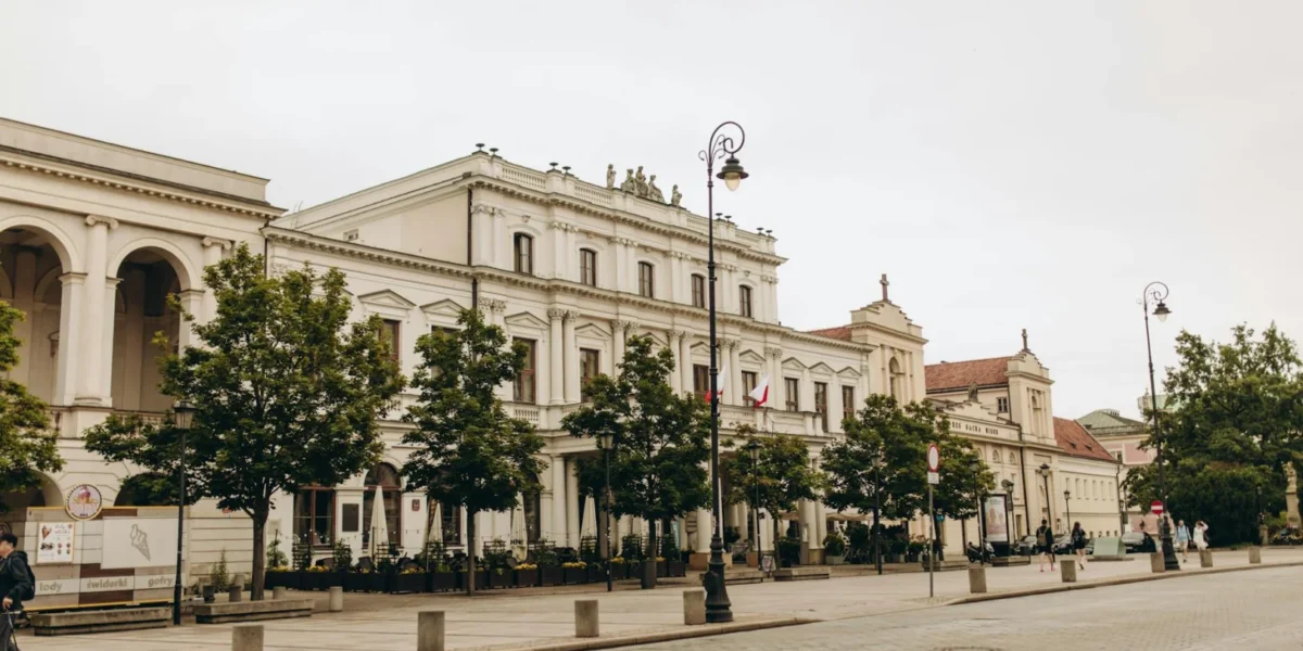 A view of Polonia House on a quiet street in Warsaw, Poland, showcasing historic architecture.