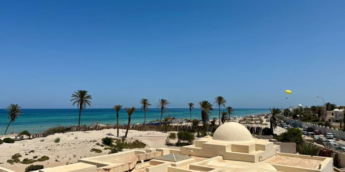 Idyllic beach scene in Médenine Governorate, Tunisia, showcasing clear skies and a vibrant seashore.