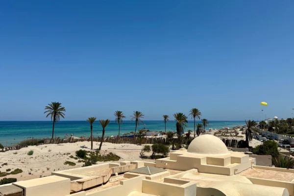 Idyllic beach scene in Médenine Governorate, Tunisia, showcasing clear skies and a vibrant seashore.