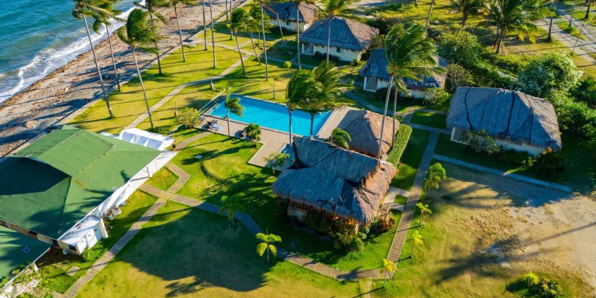Stunning aerial view of a tropical resort in Bacong, Philippines, showcasing palm trees, beach, and swimming pool.