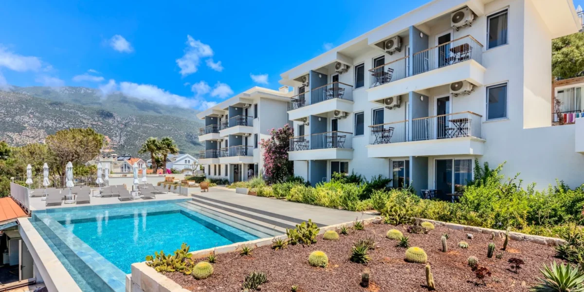Contemporary hotel with a scenic poolside view of mountains and clear skies.