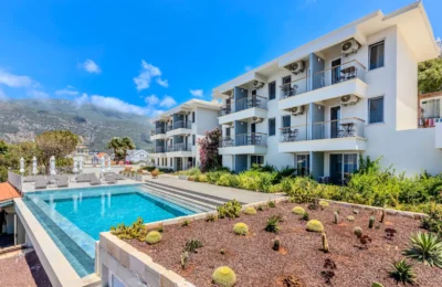 Contemporary hotel with a scenic poolside view of mountains and clear skies.