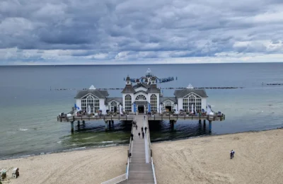 A breathtaking view of Sellin Pier extending over the calm Baltic Sea under a cloudy sky.