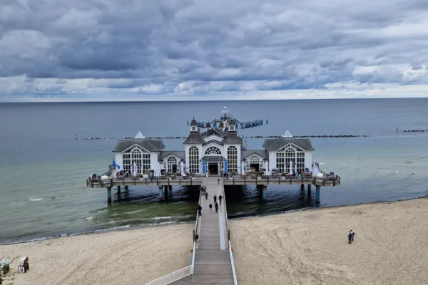A breathtaking view of Sellin Pier extending over the calm Baltic Sea under a cloudy sky.