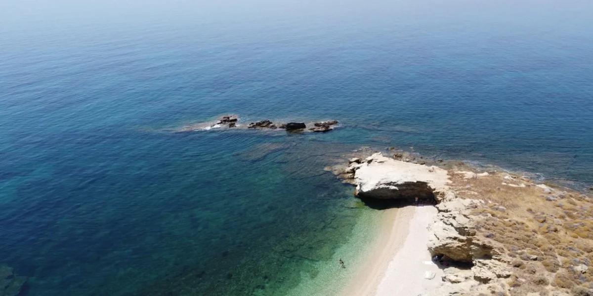 Breathtaking aerial shot of Evia Island's clear blue waters and rugged coastline in Greece.