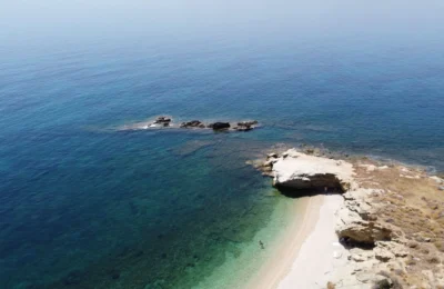 Breathtaking aerial shot of Evia Island's clear blue waters and rugged coastline in Greece.