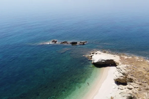 Breathtaking aerial shot of Evia Island's clear blue waters and rugged coastline in Greece.