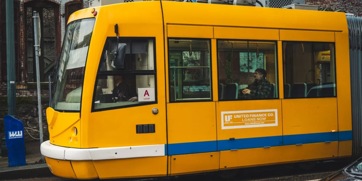 A bright yellow tram travels through the city streets, offering public transportation to passengers.
