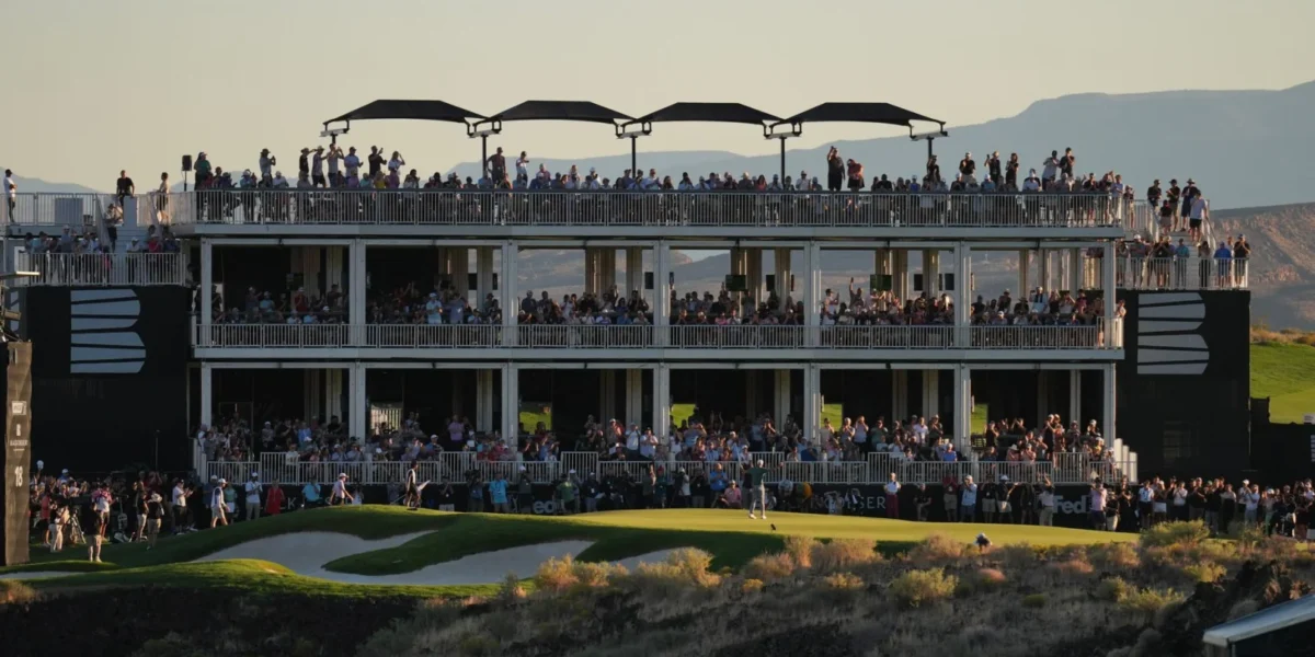Large crowd gathers on multi-level viewing structure at a golf event during sunset.