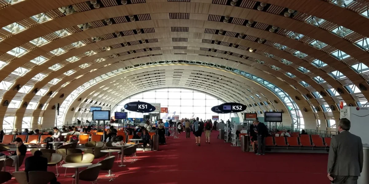 Travelers in the modern, spacious terminal of Charles de Gaulle Airport, Paris.