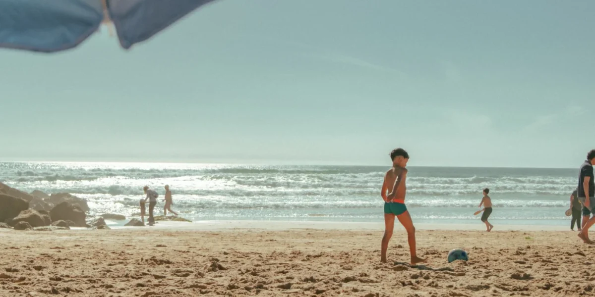 Children and adults enjoying a sunny day at a Lisbon beach, perfect for family fun.