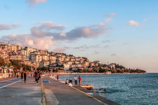 Enjoy a scenic walk along Istanbul's vibrant seaside promenade at sunset, capturing city life by the waterfront.