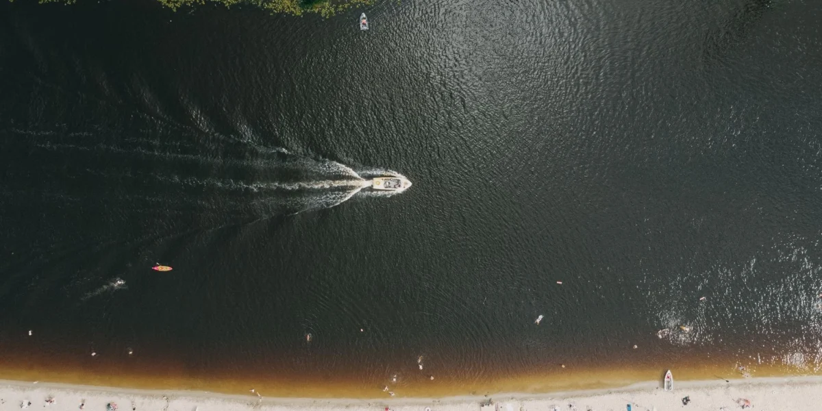 Drone shot capturing a lively beach and watercraft in Kyiv's summer atmosphere.