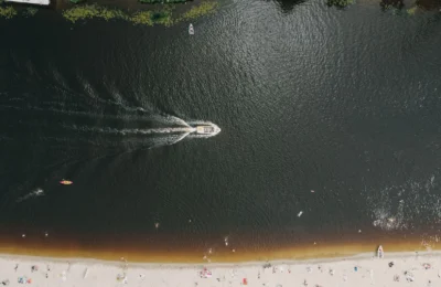 Drone shot capturing a lively beach and watercraft in Kyiv's summer atmosphere.